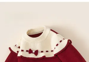 Détails de la robe en tricot rouge et crème pour fille avec col à volants et nœud