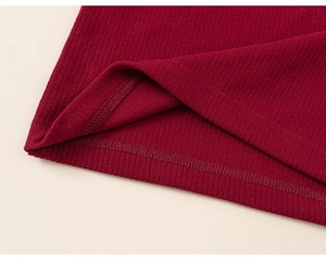 Dettaglio in maglia a costine rosso scuro con cucitura overlock pulita sull'orlo