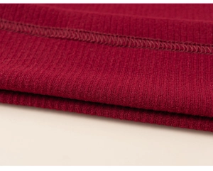 Dettaglio dell'orlo in maglia a costine rosse con cuciture piatte sul gilet invernale bimbi