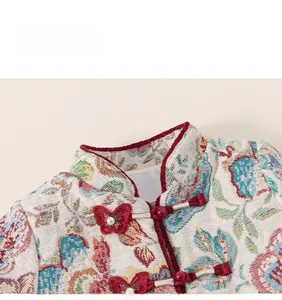 Detail of Chinese style floral jacquard top with red butterfly knot button and embroidery
