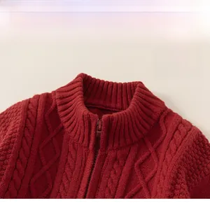 Détail d'un pull en maille torsadée rouge avec col montant classique et fermeture éclair