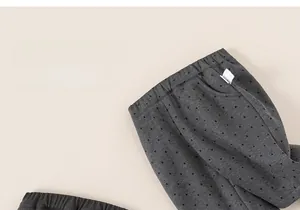Detailed view of elastic waistband and soft knitted fabric on gray polka dot toddler pants