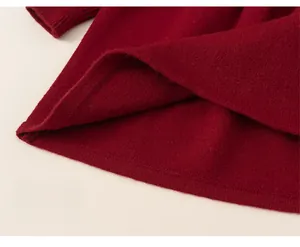 Gros plan de l'ourlet épais d'une robe en tricot rouge montrant la maille lisse
