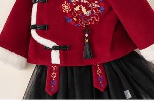 Detail of red Chinese New Year outfit with horse embroidery and white faux fur trim