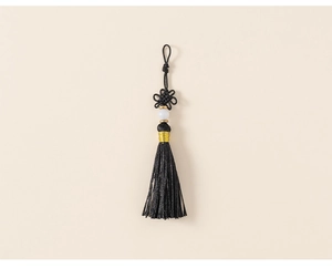 Close-up of black Chinese tassel with exquisite knot and decorative white bead
