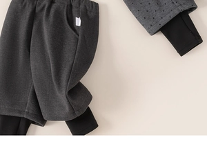 Detail of grey double-layered warm kids' trousers featuring inner black ribbed cuffs
