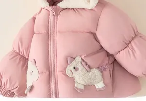 Detail of pink winter coat with sherpa lining and unicorn pockets for girls