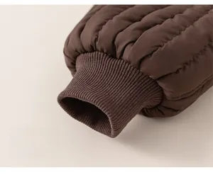 Détail du pantalon matelassé enfant marron foncé montrant les poignets élastiques côtelés