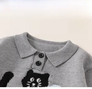 Detail of grey knitted kids sweater featuring a classic collar and black cat pattern