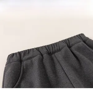 Detail view of the elastic waistband on deep gray knit trousers for children