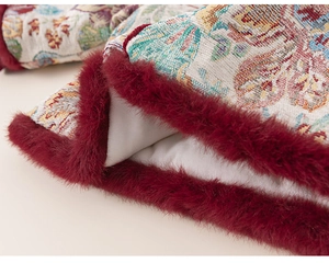 Detail of floral brocade fabric with burgundy faux fur trim on traditional girl outfit