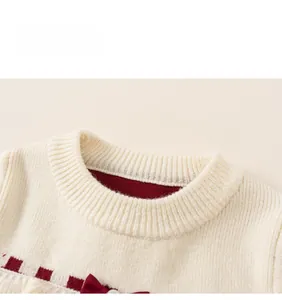 Gros plan sur le col en maille et le nœud rouge d'une robe tricotée pour enfant