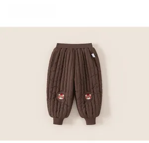 Gros plan détaillé d'un pantalon d'hiver matelassé avec écussons d'ours sur les genoux