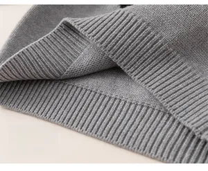 Detailed macro view of the ribbed hem on a gray knitted winter sweater for children