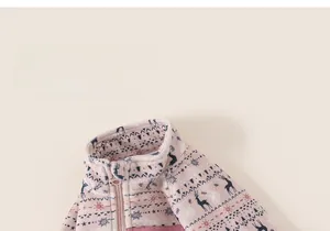 Detail of a pink fleece kid's jacket with Fair Isle reindeer and snowflake patterns