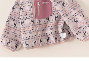 Detail of pink fleece jacket showing Fair Isle reindeer patterns and breast pocket zipper