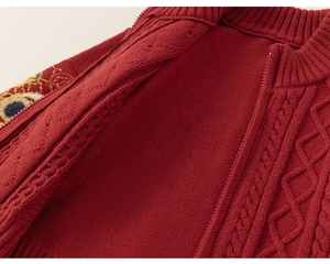 Détail du cardigan rouge en maille torsadée avec broderie ethnique et fermeture éclair