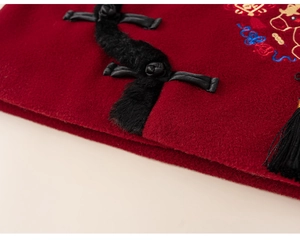 Detail of red Chinese style New Year jacket featuring traditional frog buttons and embroidery