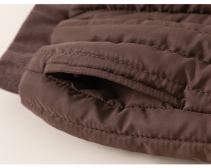 Détail d'un pantalon d'hiver matelassé marron avec tissu imperméable et bords-côtes