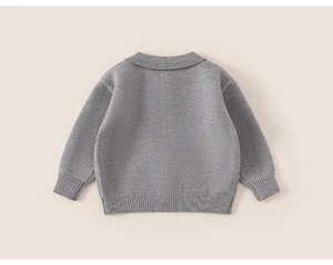 Close-up of the back of a grey knitted children sweater with ribbed cuffs and hem