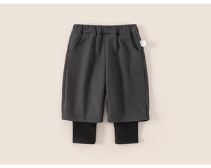 Detail of girls' layered trousers featuring grey shorts and black leggings with elastic waist
