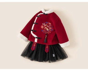 Detail of red festive top with traditional embroidery, tassels, and black tutu skirt