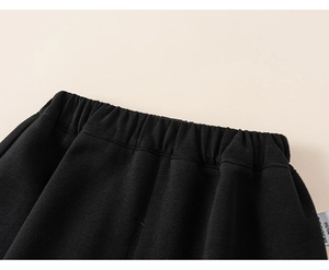 Detailed macro view of the elastic waistband on black cotton trousers for children