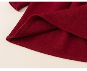 Gros plan sur la maille bordeaux et l'ourlet côtelé de cette robe en tricot pour fille