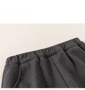 Detailed macro view of dark grey trousers with elastic waistband and side pocket texture
