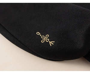 Close-up of golden knot embroidery on black knit fabric of Chinese style children's set