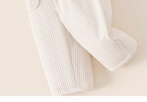 Gros plan détaillé du tissu matelassé d'un pantalon d'hiver avec surpiqûres verticales
