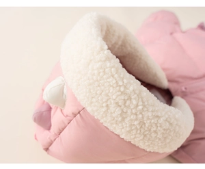 Detail of pink winter jacket featuring soft white teddy fleece hood and 3D dinosaur scales