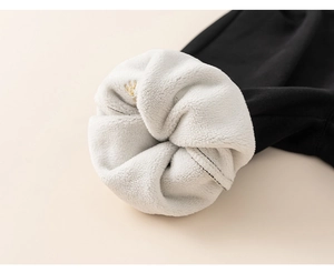 Detailed view of children's fleece lining with gold crown embroidery on black fabric