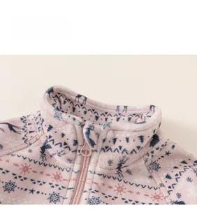 Close-up detail of child fleece jacket collar with festive reindeer and snowflake patterns