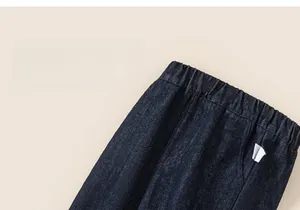 Detail of girls' warm denim jeans featuring a flexible elastic waistband and side pockets