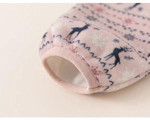 Detailed close-up of pink fleece fabric with blue reindeer and red snowflake patterns