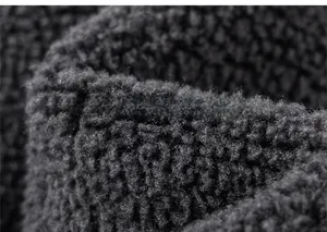 Detailed macro view of soft black sherpa fleece fabric showing warm curly texture