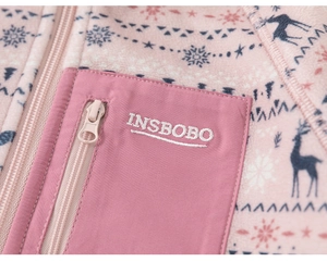 Detailed close-up of pink fleece jacket with Nordic prints and zippered logo pocket