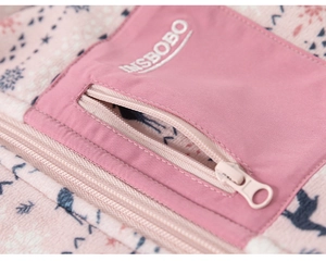 Close-up of pink fleece fabric with blue Nordic snowflake pattern and zipper pocket