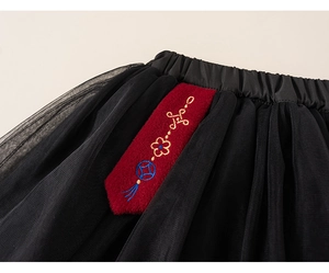 Detail of multi-layer black tulle skirt with traditional red Chinese floral embroidery