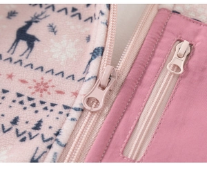 Macro shot of pink fleece jacket with blue reindeer and snowflake Nordic knit patterns