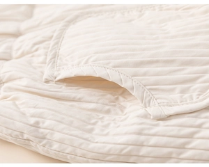 Gros plan du pantalon matelassé en coton crème avec détails de poche et texture