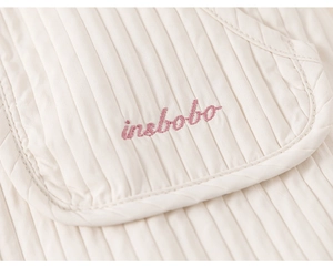 Détail du tissu en coton matelassé avec broderie insbobo rose pour pantalon enfant