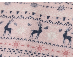 Macro detail of soft pink fleece fabric featuring festive reindeer and snowflake patterns