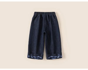 Detail of dark blue kids jeans with elastic waistband and cloud embroidery on cuffs