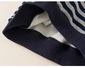 Detail of striped kids hoodie showing navy ribbed cuff and soft white fleece lining