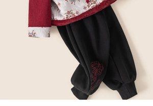 Detail of Chinese New Year kids outfit with lion pattern embroidery and red clouds