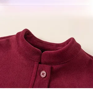 Detail view of burgundy corduroy boy's vest with classic stand collar and textured button