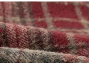 Macro detail of red and grey plaid brushed fabric for children's winter trousers