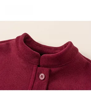 Detail of burgundy corduroy collar with matching button on a boys' traditional suit